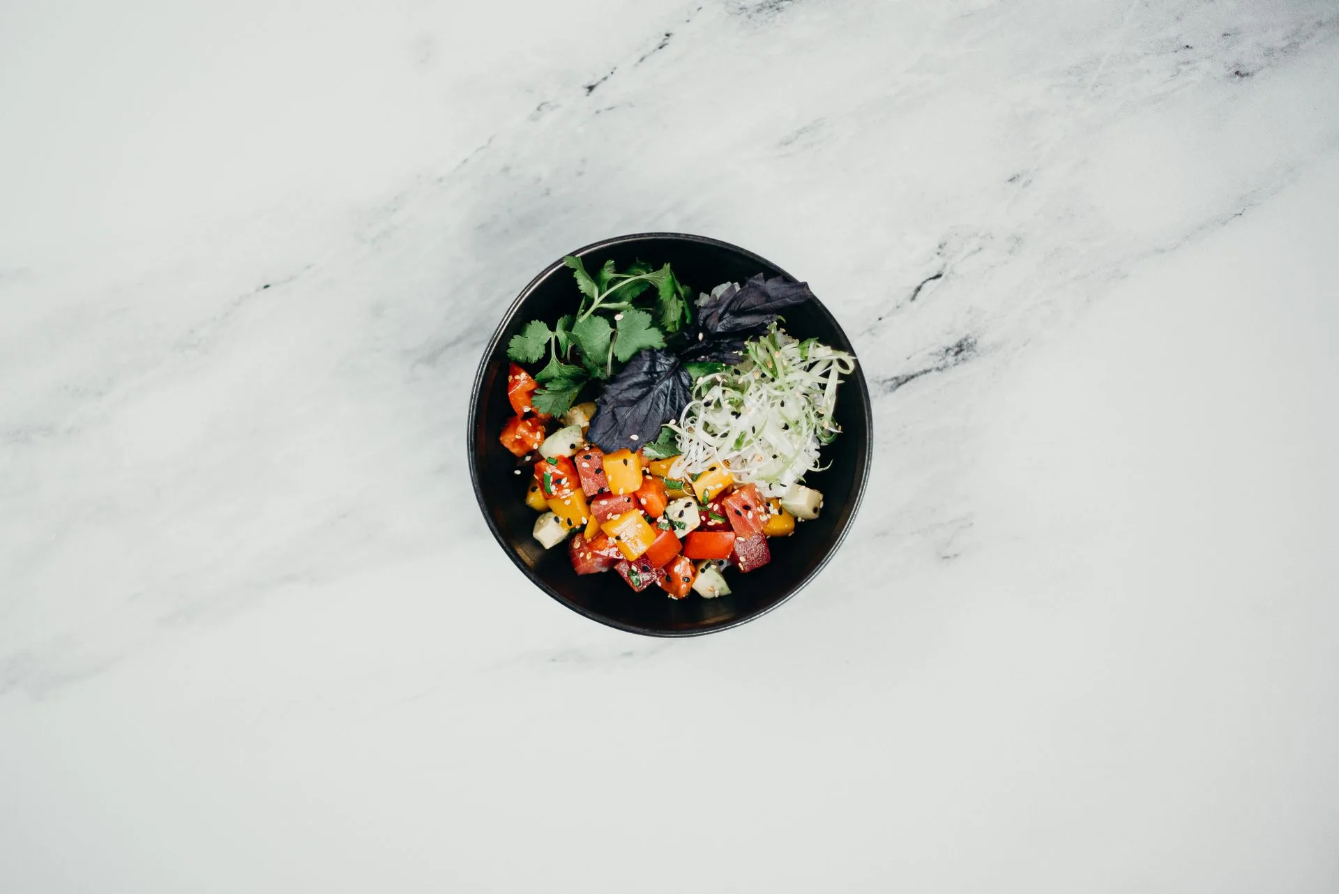 A bowl of fresh vegetable salad and herbs